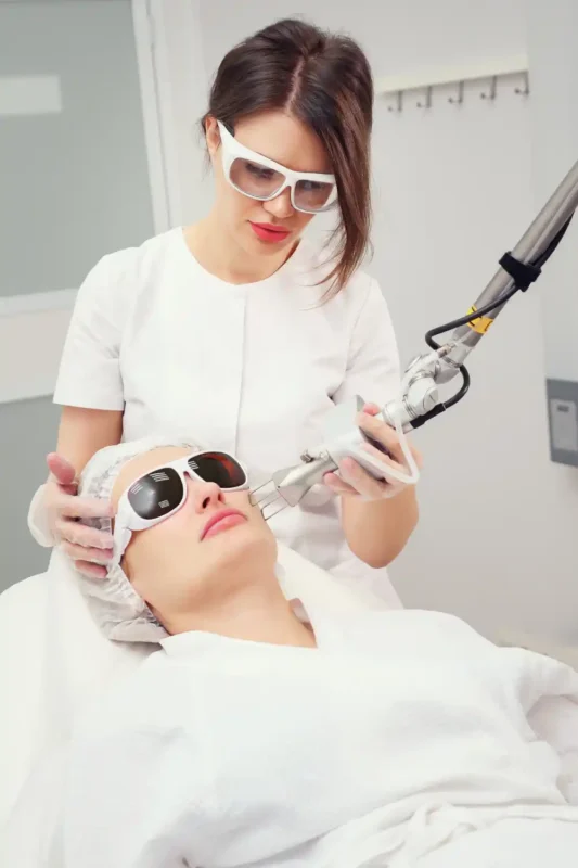 Practitioner performing laser treatment for stretch marks